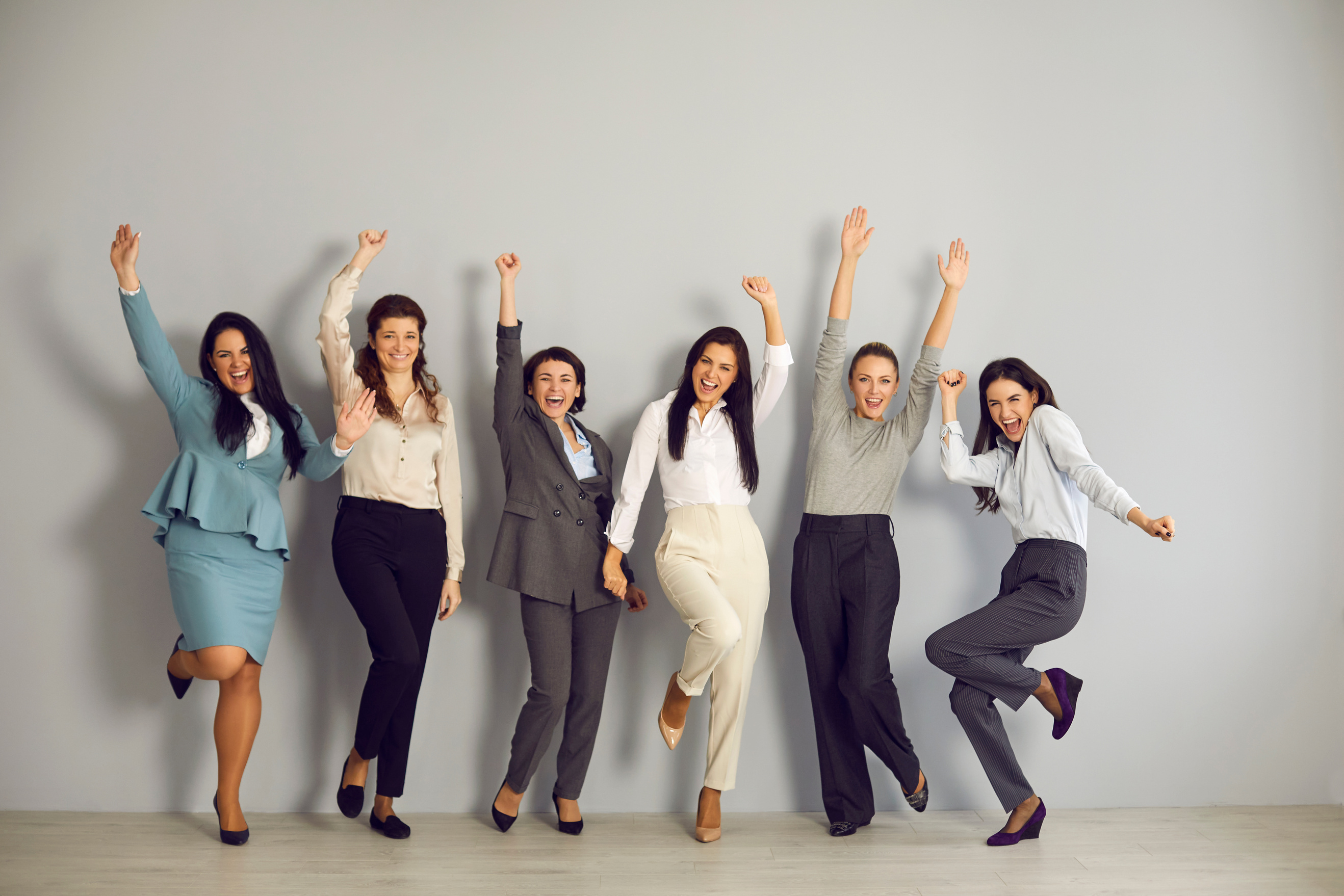 Smiling Positive Women Workers Jumping and Celebrating Business Win in Corporate Project